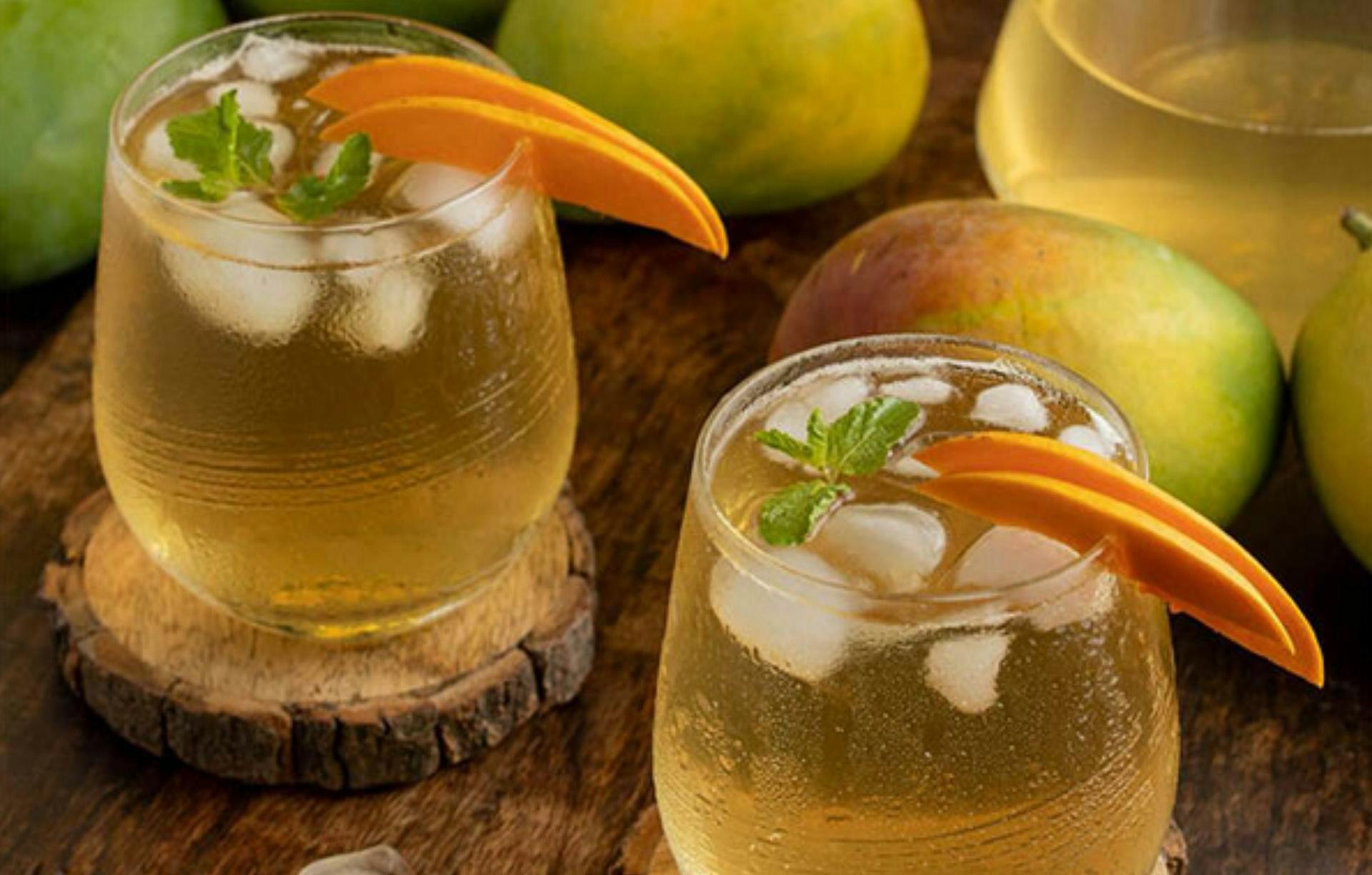 a couple of glasses filled with liquid next to some fruit